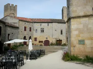 Larressingle - Terraza del café, torre almenada y las fachadas de las casas en el pueblo medieval