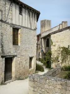 Larressingle - Strada fiancheggiata da case in pietra, e la torre merlata in background