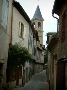 Lautrec - Narrow street lined with houses and view of the bell tower of the Saint-Rémy collegiate church