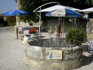 Lavardens - Puits des Larmes de Suzanne et terrasse de café ombragée de parasols