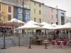 Leucate - Village Leucate en el Parque Natural Regional de Narbona en el Mediterráneo: Plaza de la República, con sus fachadas de colores y cafés al aire libre sombra sombrillas