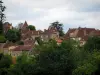 Limeuil - Houses of the medieval village, trees and cloudy sky, in Périgord