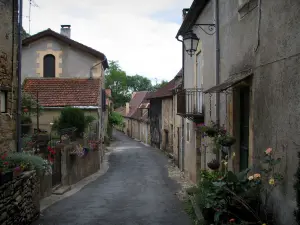 Limeuil - Flower-bedecked street of the medieval village and its houses, in Périgord