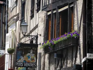 Limoges - Facciata di una casa in legno in Rue de la Boucherie con le finestre decorate con fiori, lampada e insegna di un ristorante