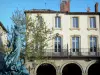 Limoux - Fachada de una casa con arcadas y estatuas fuente de la Plaza de la República