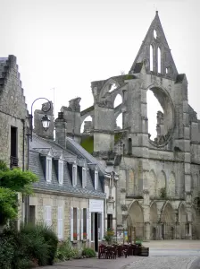 Longpont - Facade of the old abbey church of Gothic style, cafe terrace and houses in the village