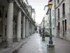 Lons-le-Saunier - Las columnas redondas con teatro de calle, alumbrado público, tiendas y fachadas de las casas