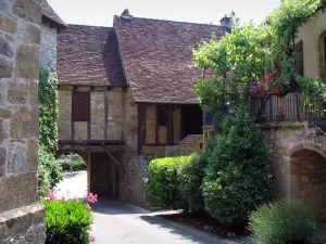 Loubressac - Huizen van het middeleeuwse dorp met struiken en bloemen, in de Quercy
