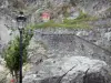 Lourdes - Lampadaire en premier plan, blason de Lourdes et montée vers le château fort