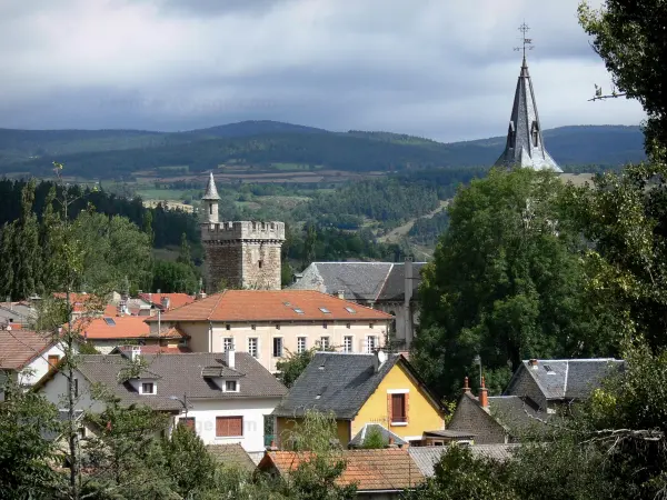 Le Malzieu-Ville - Blick auf den Uhrturm (Wachturm des ehemaligen Schlosses), Kirchturm der Kirche Saint-Hippolyte, die Häuserdächer des mittelalterlichen Ortes, und die umliegenden Landschaften; in der Margeride, im Gévaudan