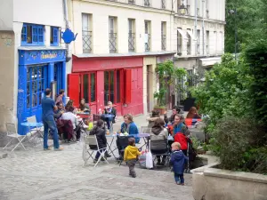 Le Marais - Café terrace and colorful storefronts of the Rue des Barres street