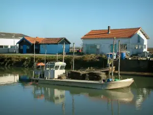 Marennes - Cayenne port: channel, boat and huts in the oyster port