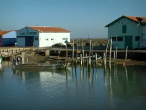 Marennes - Port de la Cayenne : chenal, barque et cabanes du port ostréicole