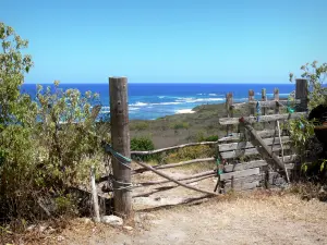 Marie-Galante - Chemin fermé par une barrière en bois, avec vue sur la mer