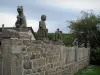 Masgot - Stone wall topped by sculptures