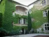 Mauriac castle - Inner courtyard of the castle with table, chairs and facade covered with ivy