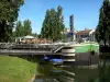 Melun - Bords de Seine : péniche amarrée avec terrasse de restaurant, fleuve Seine, façades de la ville et arbres