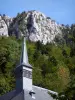 Monasterio de la Gran Cartuja - Correrie de la Gran Cartuja: torre de la iglesia, los árboles y paredes rocosas de las montañas de Chartreuse (en el Parque Regional Natural de la Chartreuse) en el municipio de Saint-Pierre-de-Chartreuse