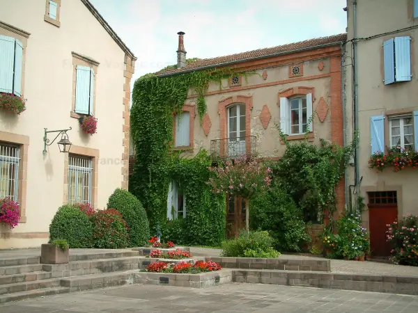 Monestiés - Plaza del pueblo con sus casas adornadas con flores y plantas