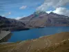 Mont-Cenis lake - Alpine pasture, lake (dam) and mountains with clouds in the blue sky, in Haute-Maurienne (peripheral zone of the Vanoise national park)