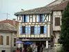 Montaigu-de-Quercy - Terrasse de café et façade à pans de bois d'une maison du village