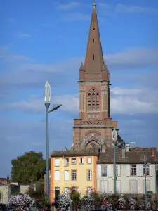 Montauban - Clocher de l'église Saint-Orens, façades de maisons, lampadaires, et rambarde fleurie (fleurs)