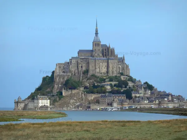 Monte Saint-Michel - Rocky islotes con Monte Saint-Michel iglesia abacial y edificios de la abadía de la abadía benedictina, casas y murallas de la ciudad medieval (aldea), las marismas