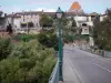 Montricoux - Puente adornado con lámparas con el fin de la torre y casas en la aldea