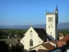 Morestel - Église gothique Saint-Symphorien et son clocher flanqué d'une tourelle en poivrière, toits de maisons de la vieille ville et paysage environnant