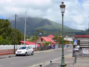 Le Morne-Rouge - Street of the town, with houses, overlooking the volcano of Mount Pelee