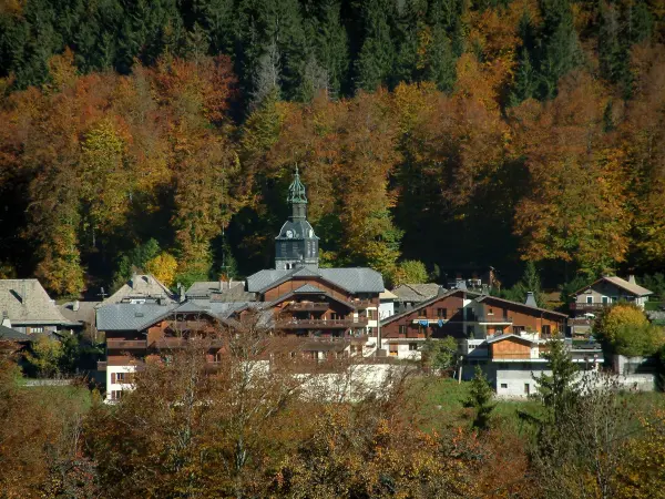 Morzine - Bäume mit den Farben des Herbstes, der Glockenturm der Kirche und Chalets des Dorfes (Sommer- und Wintersportort), im Haut-Chablais