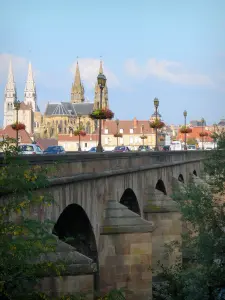 Moulins - Flower-bedecked bridge spanning the Allier river and steeples of the Notre-Dame cathedral and the Sacré-Coeur church