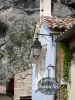 Moustiers-Sainte-Marie - Shop sign, lamppost, facades of the village and rock face