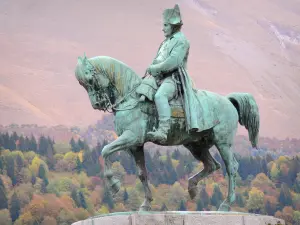 Napoleonstrasse - Reiterstatue aus Bronze von Napoleon 1. in der Wiese der Rencontre (Begegnung), Bäume mit herbstlichen Farben im Hintergrund; auf der Gemeinde Laffrey