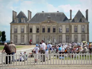 Nationalgestüt Haras du Pin - Schlossfassade, Reiter mit Pferd und Zuschauer während der Jeudis du Pins (Pferdespektakle); auf der Gemeinde Le Pin-au-Haras