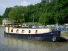 Nivernais canal - Port of Chatillon-en-Bazois with moored barges, and lock house in the background