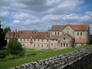 Noirlac abbey - Cistercian abbey and park with trees, clouds in the sky