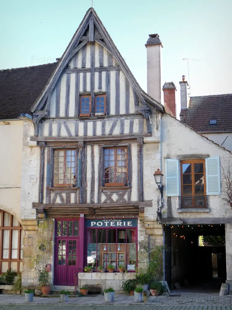Noyers-sur-Serein - Noyers: Façade d'une maison à pans de bois et devanture d'un magasin de poterie