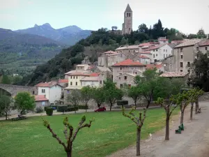 Olargues - Bell toren met uitzicht op het dorp huizen, met bomen omzoomde weide, heuvels op de achtergrond, in het Regionale Natuurpark van de Haut Languedoc