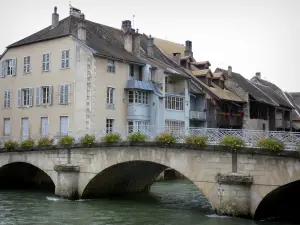 Ornans - Brücke mit Blumen überspannend den Fluss Loue und Häuser am Flussrand