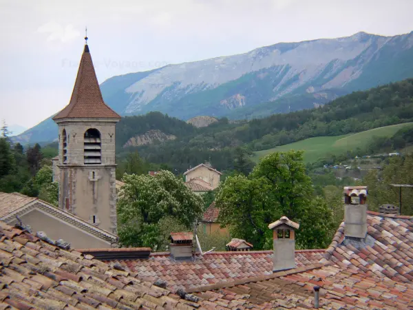 Orpierre - Clocher de l'église et toits des maisons du village avec vue sur la montagne