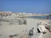 Paesaggi della Linguadoca - Spiaggia di sabbia con i turisti, rocce, Mar Mediterraneo, e gli edifici e le case della località balneare di Carnon-Plage