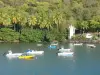 Paisajes de Guadalupe - Anse à la Barque con su faro, su verde y sus barcos en el agua ; del término municipal de antiguos habitantes y de ebullición, en la isla de Basse - Terre