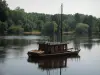 Paisajes de Indre y Loira - El pueblo de Candes-Saint-Martin, con vistas al río con un barco de madera y los árboles a la orilla del agua