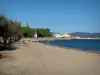 Paisajes del litoral de la Costa Azul - Playa con turistas, árboles, rocas, casas, mar Mediterráneo y las colinas en el fondo