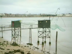 Paisajes del litoral de Loira Atlántico - Chozas de los pescadores sobre pilotes, las plazas (las redes de pesca) suspendió, el mar (Océano Atlántico) costa en el fondo del cielo y nublado, en Saint-Nazaire