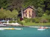 Paladru lake - Natural lake of glacial origin, pedal boats, boat, café terrace, bank, house, trees and shrubs