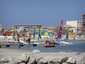 Palavas-les-Flots - Catamarans (école de voile), rochers, mer méditerranée, plage de sable, maisons et immeubles de la station balnéaire