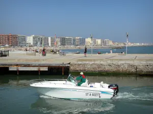 Palavas-les-Flots - Boat navigating the canal, promenade, beach, Mediterranean Sea, houses and buildings of the seaside resort