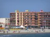 Palavas-les-Flots - Spiaggia di sabbia con i turisti, parco giochi, Mar Mediterraneo, case e gli edifici della stazione